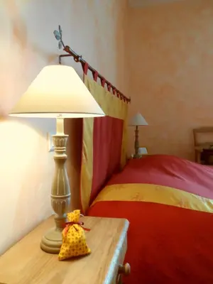 a stuffed animal sitting on a table next to a bed at Mas la Cigaliere in Venasque