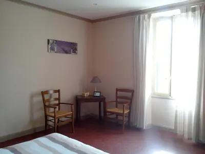 a bedroom with two chairs and a table and a window at Mas la Cigaliere in Venasque