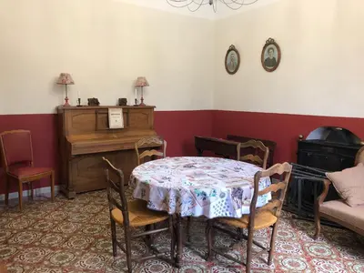 a dining room with a table and a piano at Mas la Cigaliere in Venasque
