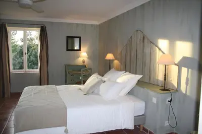 a bedroom with a bed with white sheets and pillows at Le Mas Vigneron in Gordes
