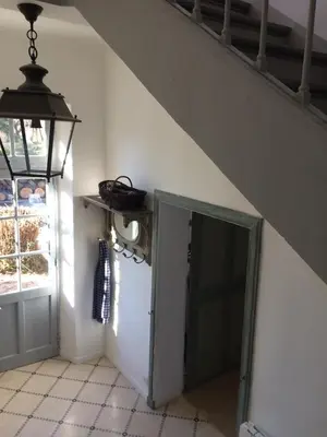 a hallway with an open door under a staircase at La Calade in Lourmarin