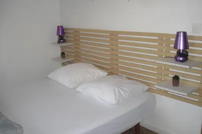 a bed with two pillows and two lights on it at Lou mas li Pitchoun 