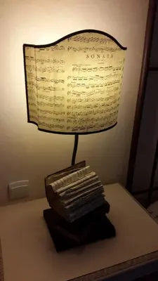 a lamp sitting on top of a table with a book at Hotel du Poète in Fontaine-de-Vaucluse