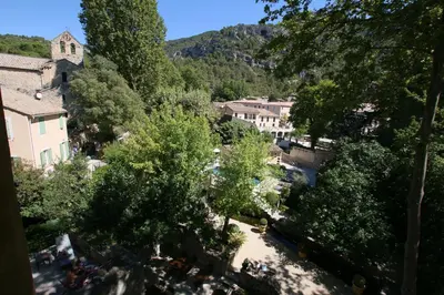 a view of a town with trees and buildings at Hotel du Poète in Fontaine-de-Vaucluse
