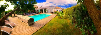 a wooden deck with a swimming pool and a house at Villa Felin Feline in LʼIsle-sur-la-Sorgue