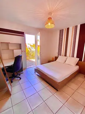 a bedroom with a bed and a desk and a chair at Villa Felin Feline in LʼIsle-sur-la-Sorgue