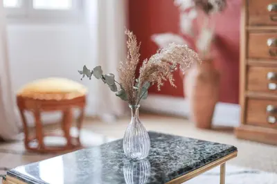 a glass vase with flowers sitting on a table at La Madone in Apt