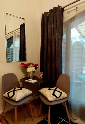 a room with two chairs and a table with a mirror at Les Jardins d'Eleusis in Murs