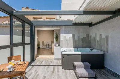 a bathroom with a bath tub and a table at Nuit Etoilée in LʼIsle-sur-la-Sorgue