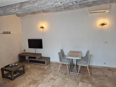 a living room with a table and chairs and a tv at Nuit Etoilée in LʼIsle-sur-la-Sorgue