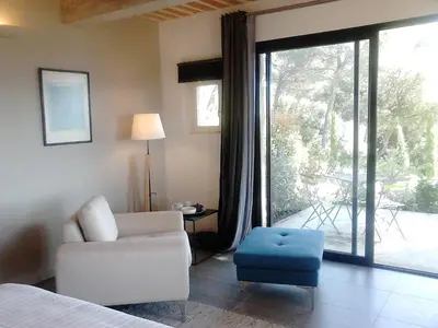 a living room with a couch and a chair and a window at La Maison de Charlie in Vaugines