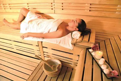 a woman laying in a sauna in a bath tub at Aquabella Hôtel & Spa in Aix-en-Provence