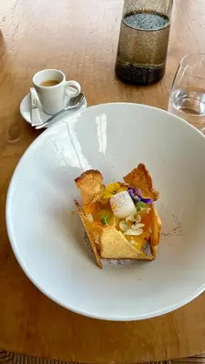 a white plate with a piece of food on a table at Aquabella Hôtel & Spa in Aix-en-Provence