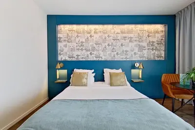 a bedroom with a large bed with a blue wall at Aquabella Hôtel & Spa in Aix-en-Provence
