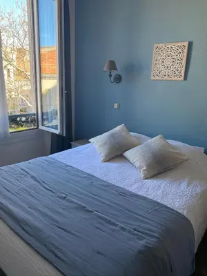 a blue bedroom with a large bed with two pillows at Grand Hôtel De La Poste in Salon-de-Provence