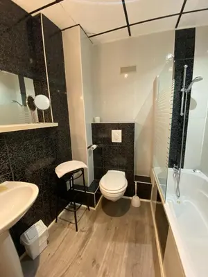 a bathroom with a toilet and a sink and a tub at Grand Hôtel De La Poste in Salon-de-Provence