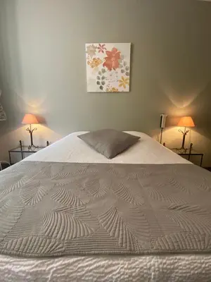 a bed with a white comforter in a bedroom at Grand Hôtel De La Poste in Salon-de-Provence