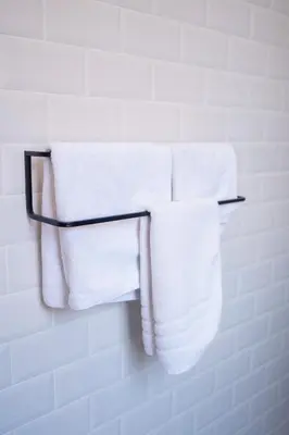 a group of towels hanging on a towel rack in a bathroom at Hôtel d'Angleterre, Salon-de-Provence in Salon-de-Provence