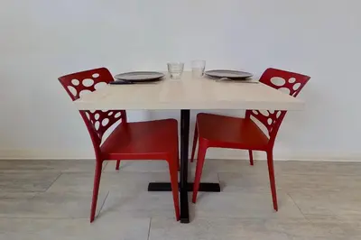 a table with two chairs and a table with plates and glasses at City Résidence Aix-en-Provence in Aix-en-Provence