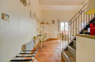 a living room with stairs and a table and chairs at Omma in Roussillon