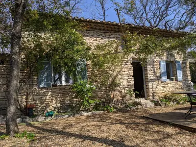 a brick house with a table in front of it at Les Rapieres Mireio in Gordes