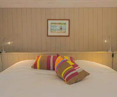 a bedroom with a bed with two pillows on it at Le Cabanon in Le Thor