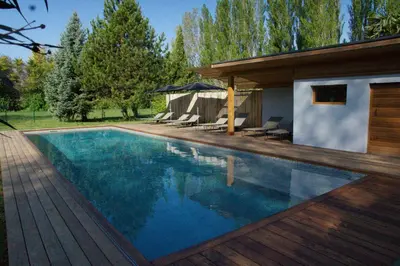 a swimming pool in a backyard with a house at Le Cabanon in Le Thor