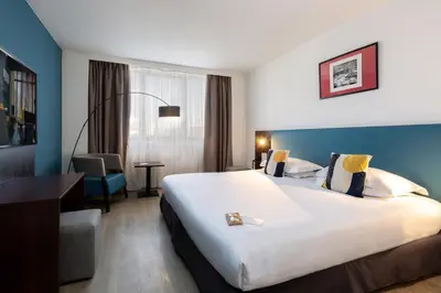 a hotel room with a bed and a couch at Best Western Hotel le Galice Aix-en-Provence in Aix-en-Provence