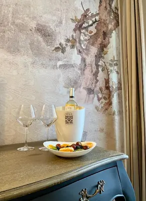 a bottle of wine and a plate of food on a table at Hôtel des Augustins in Aix-en-Provence