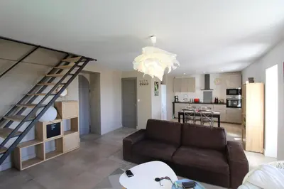 a living room with a couch and a staircase at The Panoramic House in Lagnes