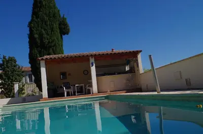 a swimming pool in front of a house with a pergola at le clos des sources in Saint-Chamas