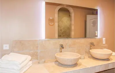 a bathroom with two sinks and a large mirror at Amazing Home In Lançon De Provence in Lançon-Provence