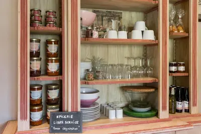 a hutch filled with plates and bowls and dishes at Un Coin de Provence in LʼIsle-sur-la-Sorgue