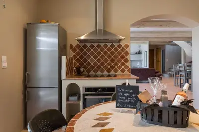 a kitchen with a stainless steel refrigerator and a stove at Un Coin de Provence in LʼIsle-sur-la-Sorgue