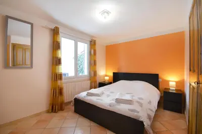 a bedroom with orange walls and a bed and two lamps at Mas et Gite de la Picholine in LʼIsle-sur-la-Sorgue