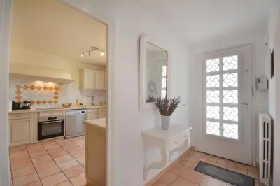 a kitchen with white cabinets and a door with a window at Mas et Gite de la Picholine in LʼIsle-sur-la-Sorgue