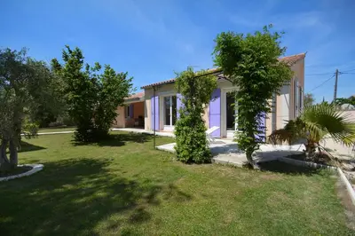 a house with a green yard in front of it at Mas et Gite de la Picholine in LʼIsle-sur-la-Sorgue