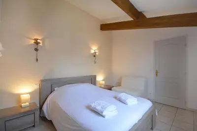a bedroom with a white bed with two pillows on it at Mas et Gite de la Picholine in LʼIsle-sur-la-Sorgue