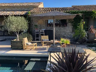 a patio with an umbrella and chairs and a table at Villa Cabrida in Cabrières-dʼAvignon