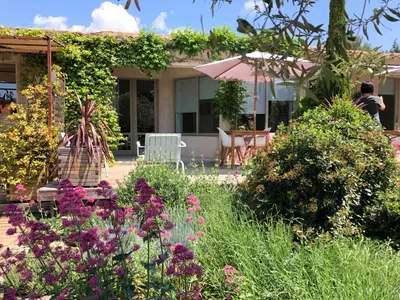 a garden in front of a house with flowers at Villa Cabrida in Cabrières-dʼAvignon