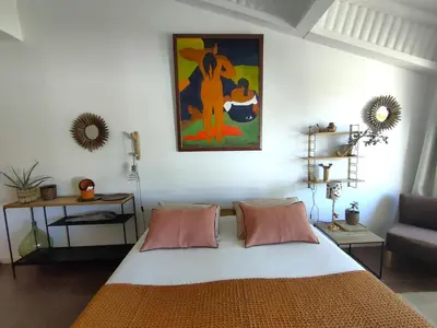 a bedroom with a bed and a painting on the wall at Villa Cabrida in Cabrières-dʼAvignon