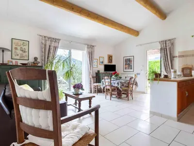 a living room with a chair and a table at Holiday Home Les Vignes by Interhome in Ménerbes