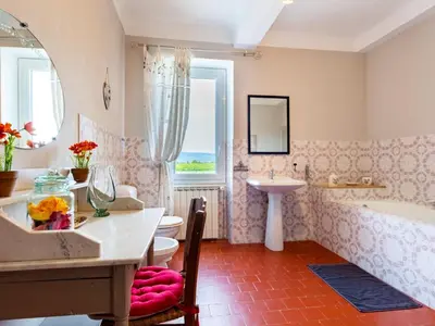 a bathroom with a sink and a tub and a table at Holiday Home L'Olivier by Interhome in Ménerbes