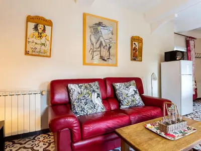 a red leather couch in a living room with a table at Holiday Home L'Olivier by Interhome in Ménerbes