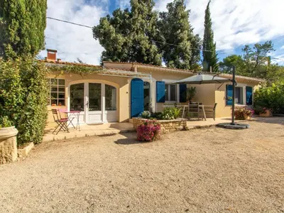 a small house with a patio and an umbrella at Holiday Home Les Amandiers by Interhome in Mazan