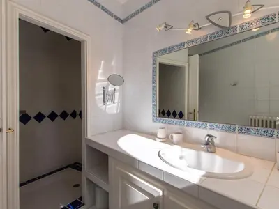 a white bathroom with a sink and a mirror at Holiday Home Les Amandiers by Interhome in Mazan