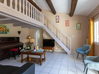 a living room with a staircase and a piano at Holiday Home Les Amandiers by Interhome in Mazan