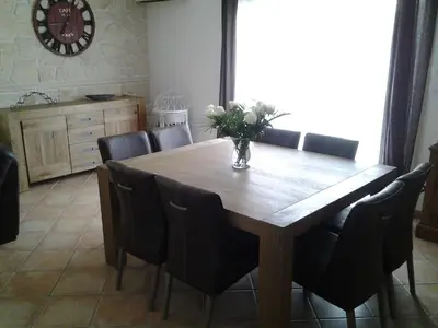 a dining room table with chairs and a vase of flowers on it at Maison les pins in Vedène