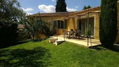 a patio with a table and chairs in a yard at Maison les pins in Vedène