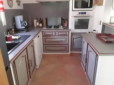 a kitchen with white cabinets and a stove top oven at Maison les pins in Vedène